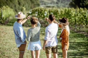 Group of young friends tasting wine on the vineyard